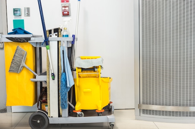 Balde de esfregão amarelo e conjunto de equipamentos de limpeza no aeroporto