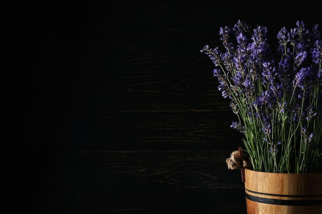 Balde de madeira com lavanda em fundo de madeira