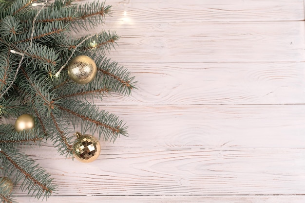 Balde elegante de brinquedos de Natal dourados em uma madeira branca e galhos de árvores de Natal