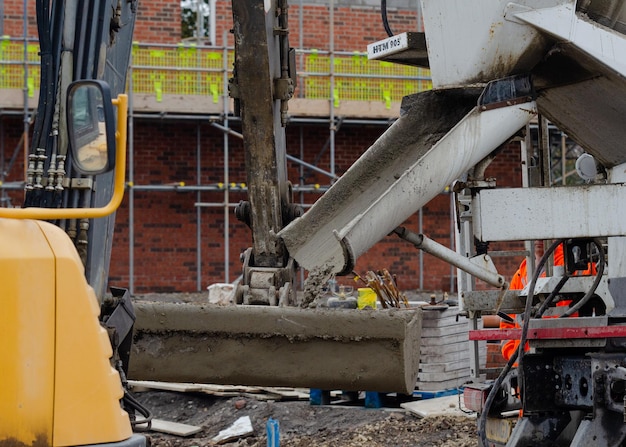 Balde exavator lleno de hormigón húmedo para llevarlo al lugar de las obras de hormigón en el sitio de construcción