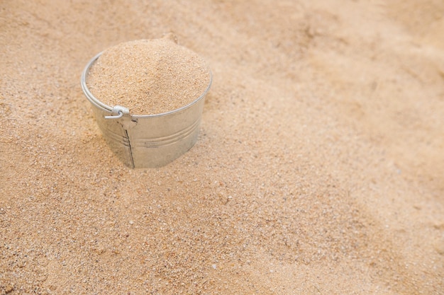 Foto balde na pilha de areia