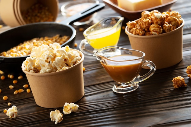 Baldes de papel com manteiga e pipoca de caramelo na mesa da cozinha