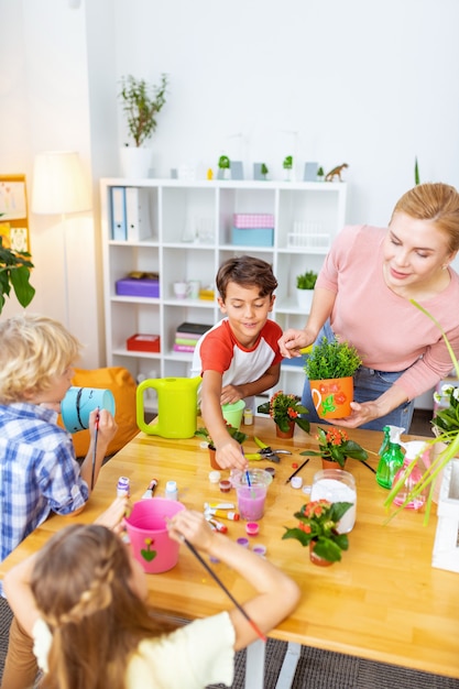 Baldes para plantas. três alunos fofos e espertos participando da aula de ecologia em baldes de colorir para plantas