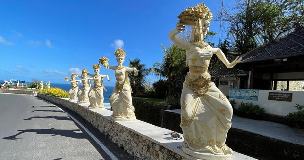 Bali, Indonesia 06 de julio de 2022 Escultura de bailarines balineses en la entrada de la playa de Pantai Melasti bajo el cielo azul