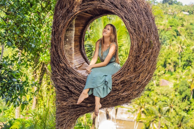 Bali tendencia nidos de paja en todas partes Joven turista disfrutando de su viaje por la isla de Bali Indonesia Haciendo una parada en una hermosa colina Foto en un entorno natural de nido de paja Estilo de vida