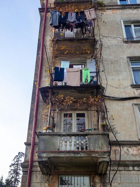 Balkone eines alten Hauses Vintage-Architektur von Georgien Fassade eines alten Gebäudes, das in der Sowjetunion gebaut wurde Wohnungen für viele Menschen Sowjetunion Architektur erfordert Reparaturen Wäsche trocknen draußen