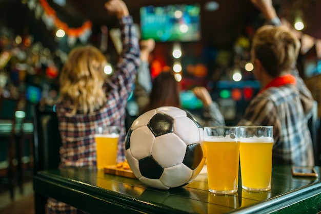 Ball und Bier auf dem Tisch in der Sportbar