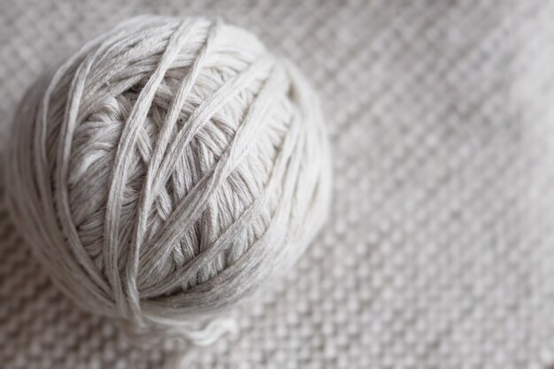 Ball von Threads auf einem gestrickten Hintergrund