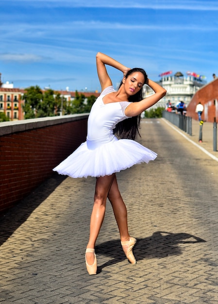 Ballerina auf Pointe macht eine Pose auf der Straße