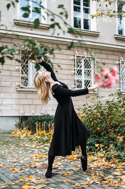 Ballerina tanzt im Herbst Stadtstraße moderne Balletttänzerin in schwarzen Spitzenschuhen im Freien