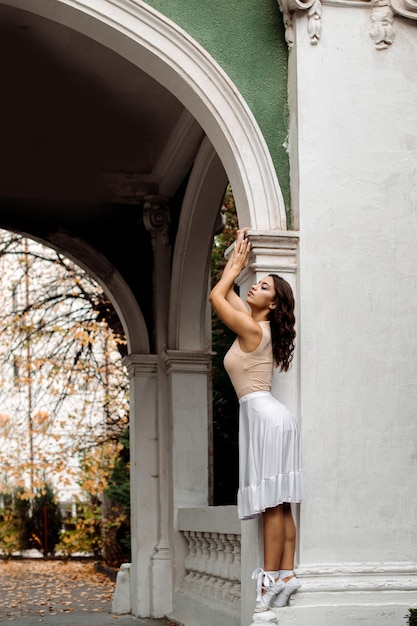 Ballerine der jungen Frau tanzt draußen am alten Gebäude oder im Museum