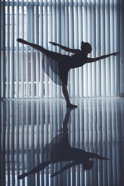 Foto balletttänzerin tanzt in der nähe des fensters