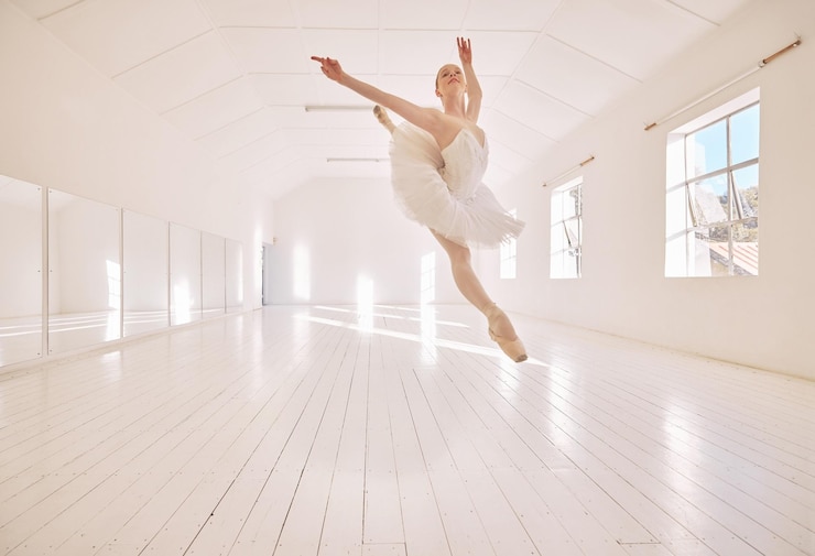 Foto balletttanzsprung und studiotänzerin tanzen schöne elegante oder klassische aufführung im theaterraum bühnenkünstler professionelle theaterballerina und kreative frau mit energie, die sich mit schönheit bewegt