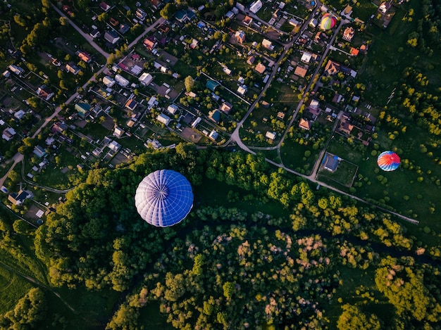 Balões de ar quente Balões de ar quente de vista aérea voando sobre o campo de verão