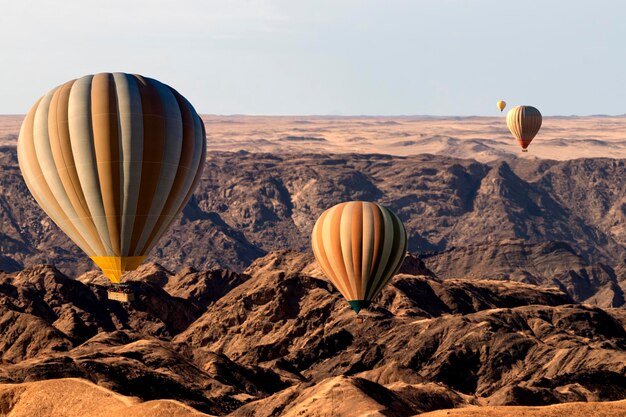 Balões de ar quente coloridos voando sobre a montanha do vale da lua áfrica