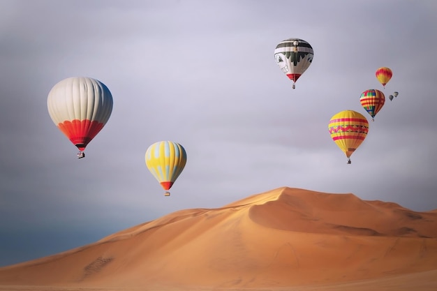 Balões de ar quente coloridos voando sobre as dunas de areia ao pôr do sol