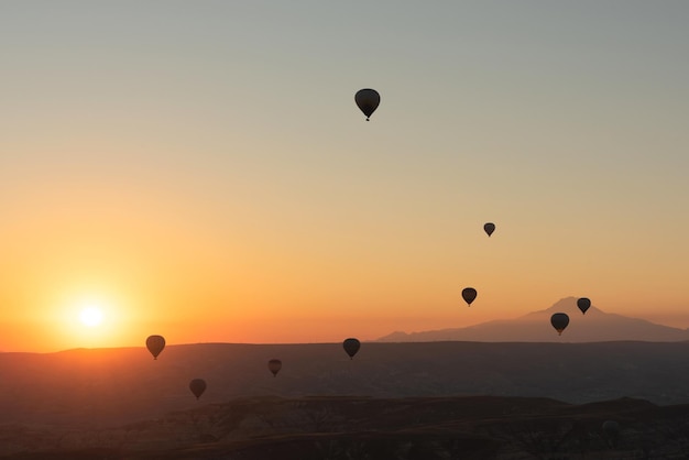 Balões de ar quente no céu durante o nascer do sol Sonhos de viagem se tornam realidade