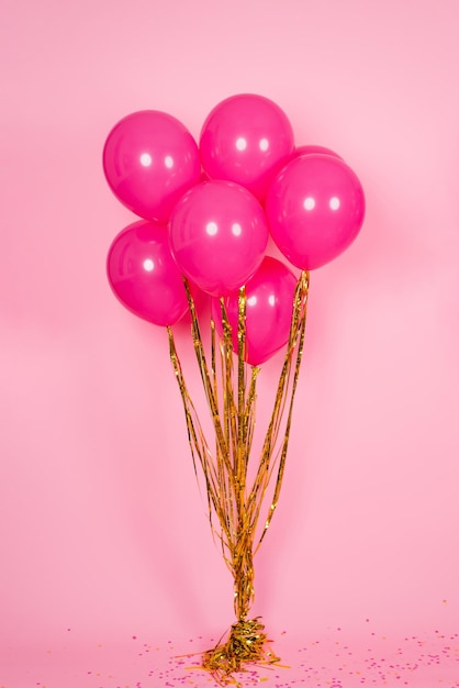 Balões festivos fúcsia ou rosa com fios de ouro coletados em um buquê para um aniversário Dia dos Namorados ou Dia das Mães