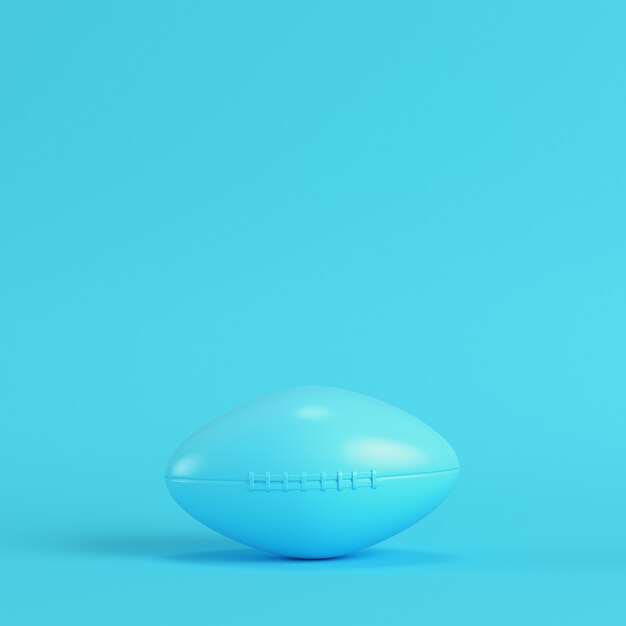 Balón de fútbol americano sobre fondo azul brillante