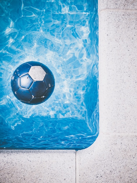 Foto balón de fútbol azul en la piscina