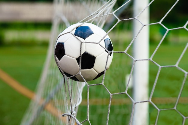 Balón de fútbol blanco y negro en la puerta. Concepto de victoria en el partido