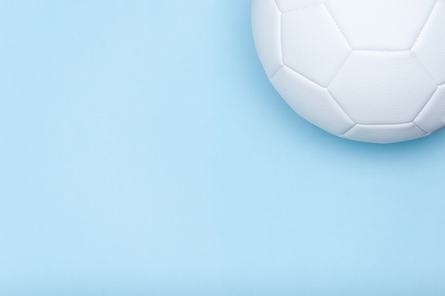 Foto balón de fútbol blanco sobre fondo azul. copie el espacio. visión de conjunto.