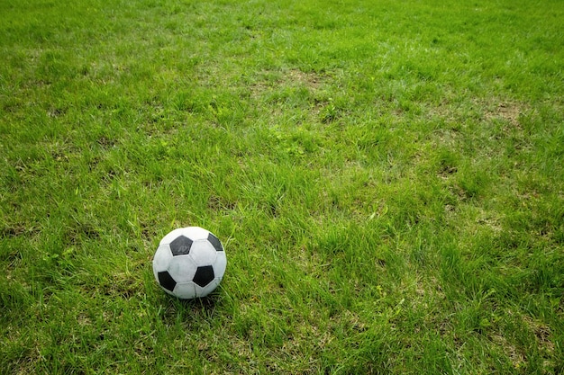 Balón de fútbol en campo de hierba verde con gran espacio de copia