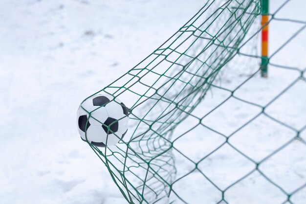 Balón de fútbol clásico marca un gol en tiempo nevado