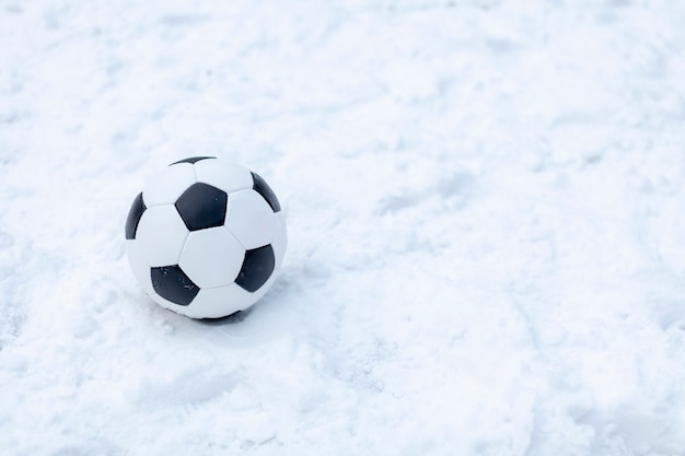 Balón de fútbol clásico marca un gol en tiempo nevado