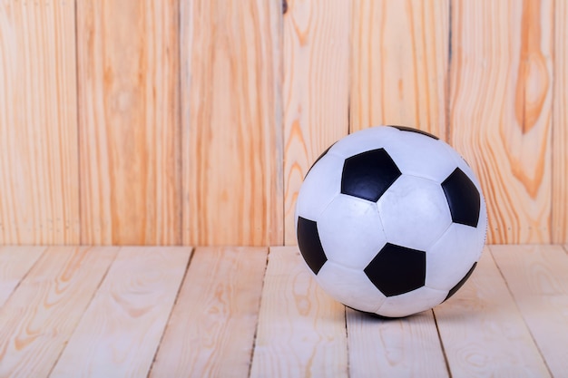 Balón de fútbol colocado sobre madera.