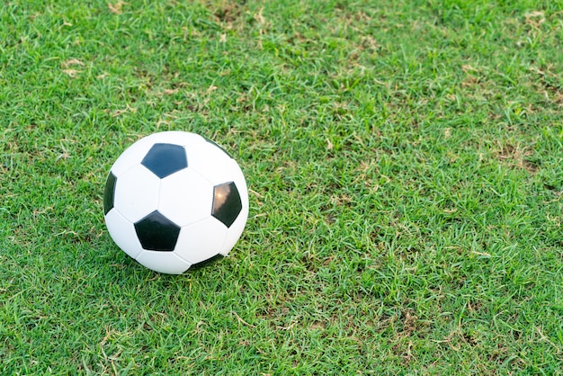 Balón de fútbol en el fondo del campo de fútbol con espacio de copia