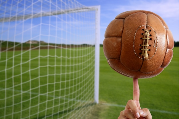 Balón de fútbol en la mano portería neta de fútbol