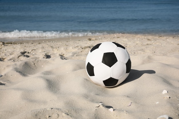 Balón de fútbol en la playa espacio para texto Equipo de fútbol