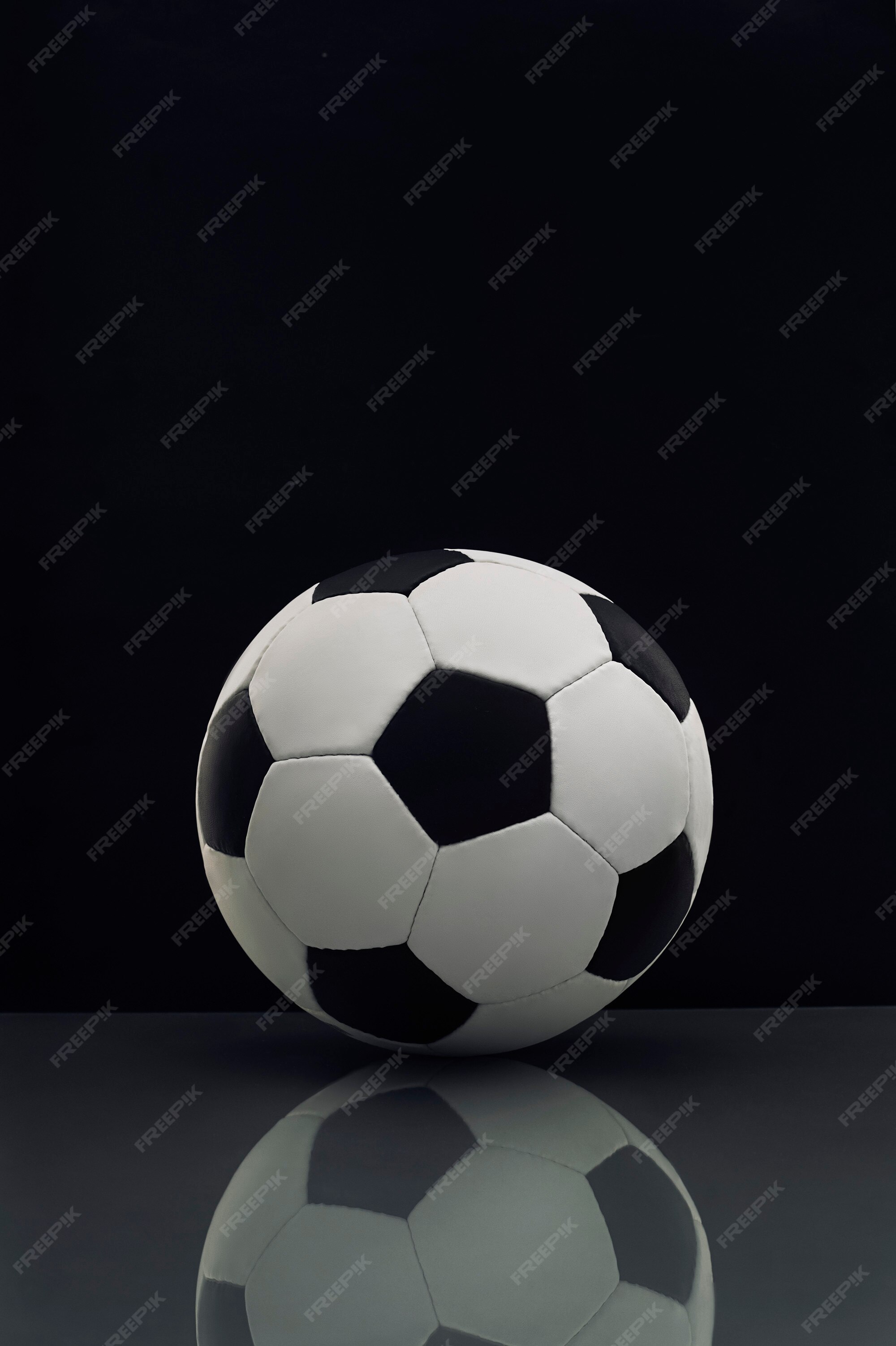 Balón de fútbol con reflexión sobre la mesa en la oscuridad | Foto Premium Balón de fútbol con reflexión sobre la mesa en la oscuridad | Foto Premium