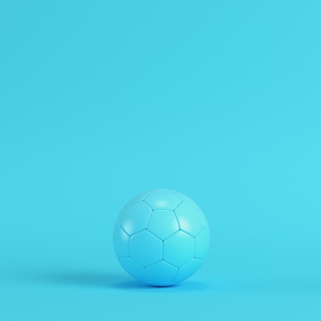 Balón de fútbol sobre fondo azul brillante