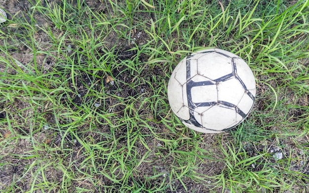 Balón de fútbol viejo en la hierba del campo de fútbol, ​​fútbol en las hierbas