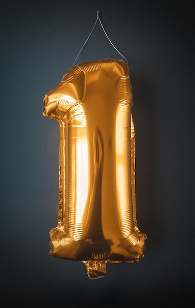 Balón de papel dorado número uno aislado sobre fondo negro