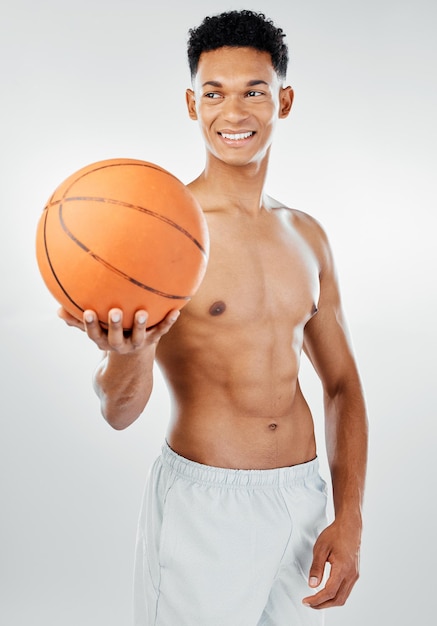 Baloncesto deportivo y hombre en un gimnasio después de entrenar o hacer ejercicio con una sonrisa en la cara Bienestar de fondo blanco y modelo de fitness feliz o jugador de baloncesto con espacio de maqueta
