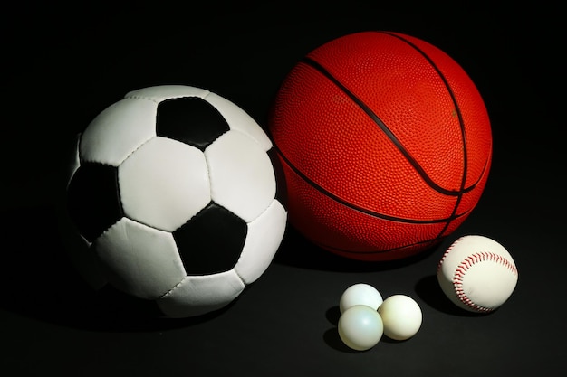 Foto balones deportivos sobre un fondo negro