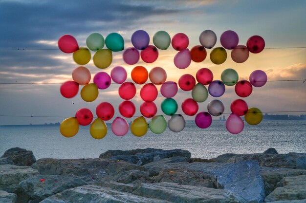 Foto balones multicolores en la roca en el mar