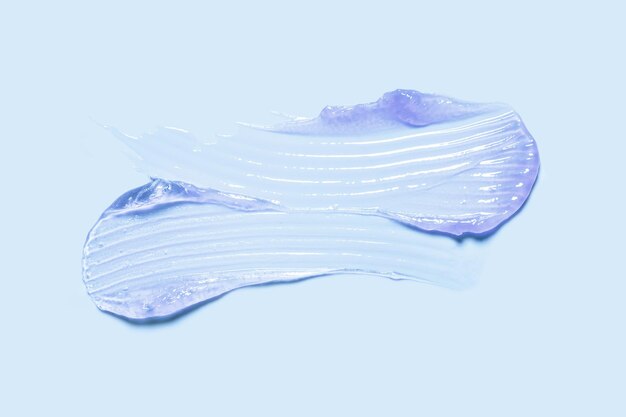 Foto bálsamo labial máscara lila roxa textura colorida amostra mancha em fundo azul
