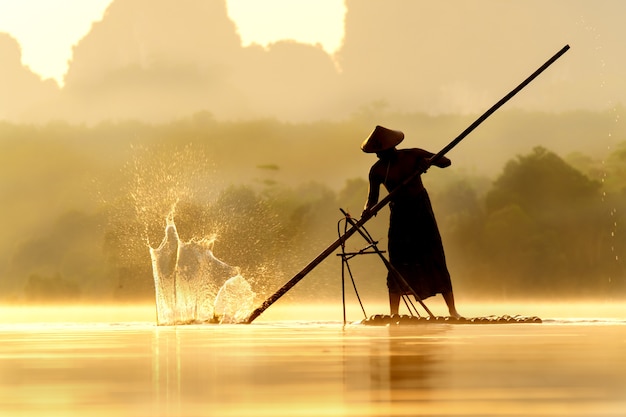 Bambu de uso de pescador bateu na superfície da água