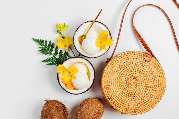 Bambusbeutel und Eiscreme in der Hälfte der Kokosnuss. Sommerferien-Konzept.