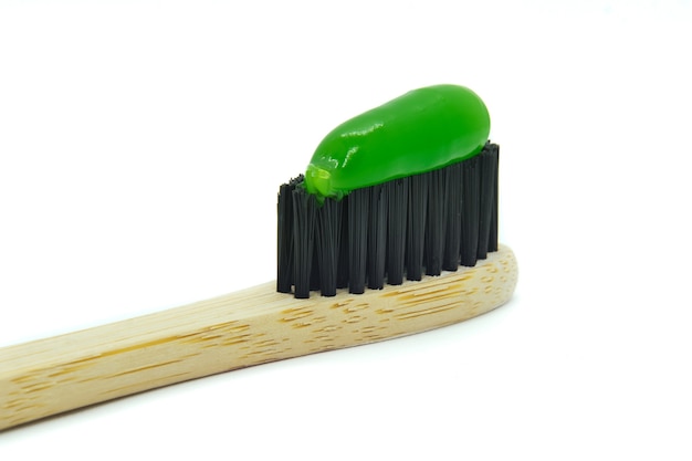 Foto bambuszahnbürste mit grüner minze zahnpasta isoliert auf weiss persönliches mundhygienekonzept