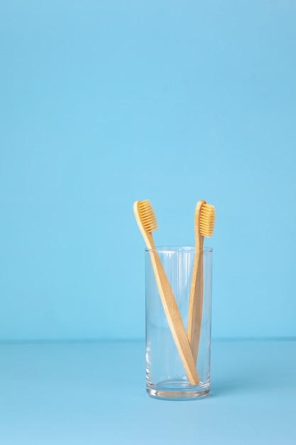 Bambuszahnbürsten auf blauem Hintergrund in einem Glas umweltfreundliche Körperpflegeprodukte für Menschen