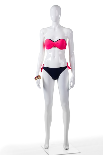 Bañador rosa y negro. Maniquí de mujer en traje de baño bicolor. Ropa de playa brillante para mujer con brazaletes. Traje de baño de moda en tienda outlet.