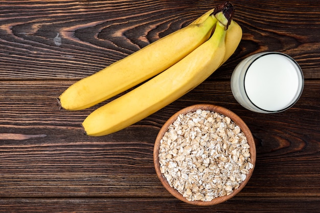 Banana, aveia e copo de leite na mesa