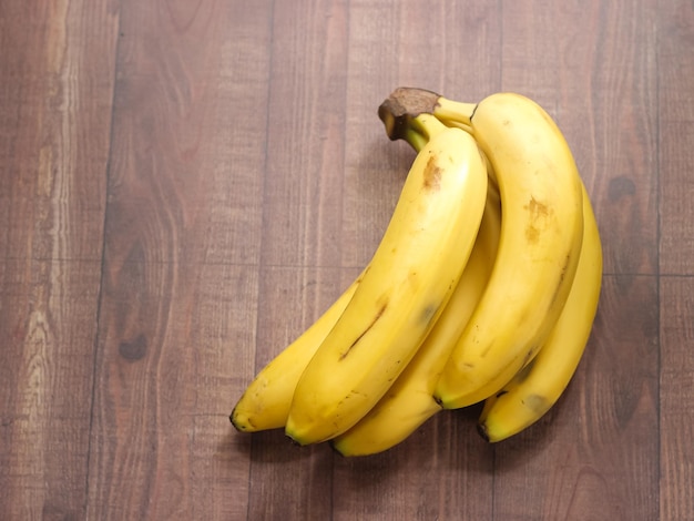 Banana cavendish orgânica madura em fundo de madeira com traçado de recorte