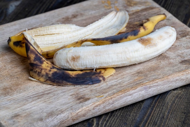 Banana enegrecida velha em uma tábua de cortar alimentos de frutas de banana perecíveis