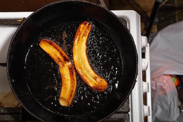 Banana frita na frigideira Banana crua cozida em óleo